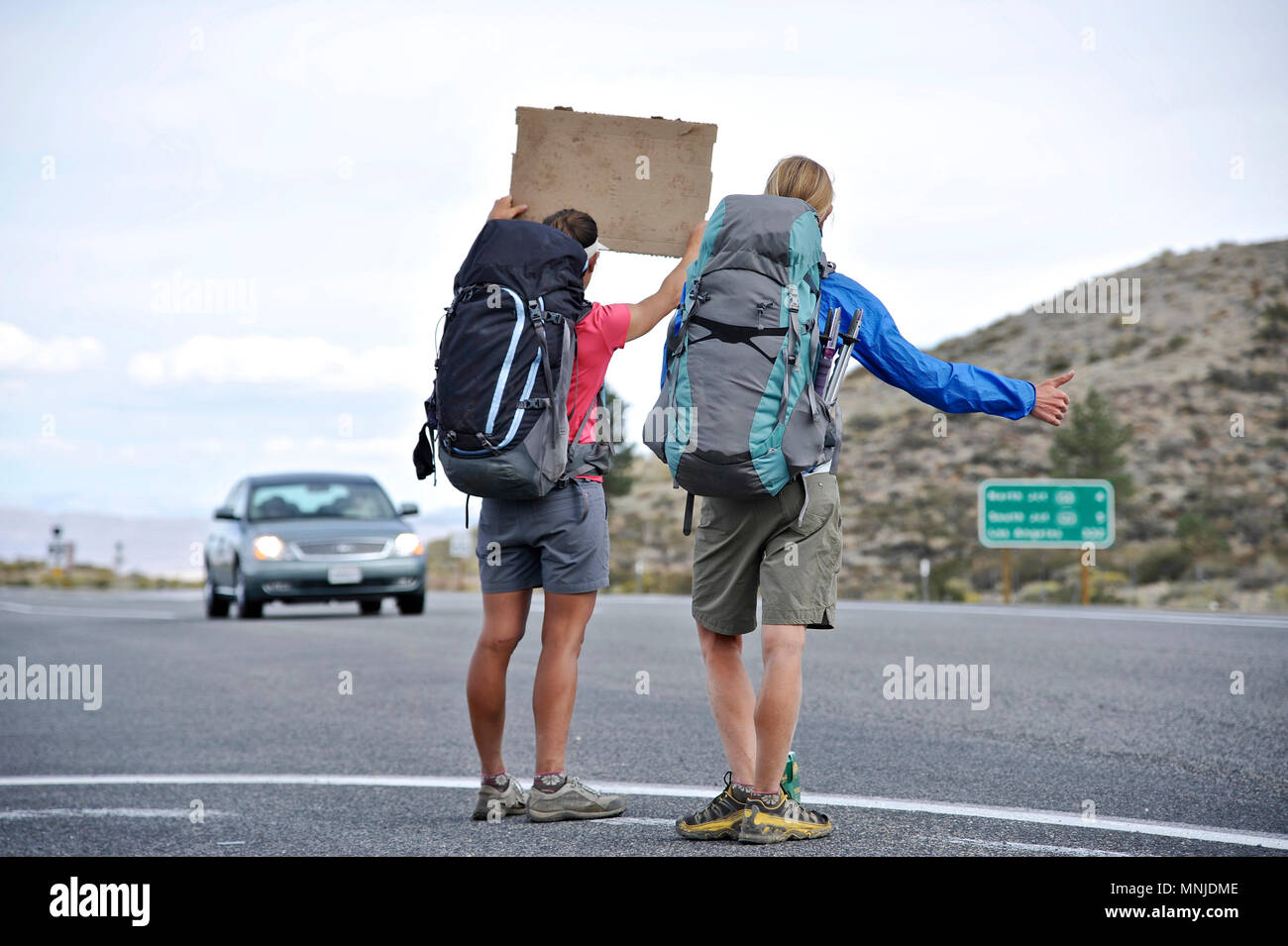 Backpackers hitchhike in Lee Vining after completing a two-week trek of the Sierra High Route Yosemite National Park, California. The 200-mile route roughly parallels the popular John Muir Trail through the Sierra Nevada Range of California from Kings Canyon National Park to Yosemite National Park. Stock Photo