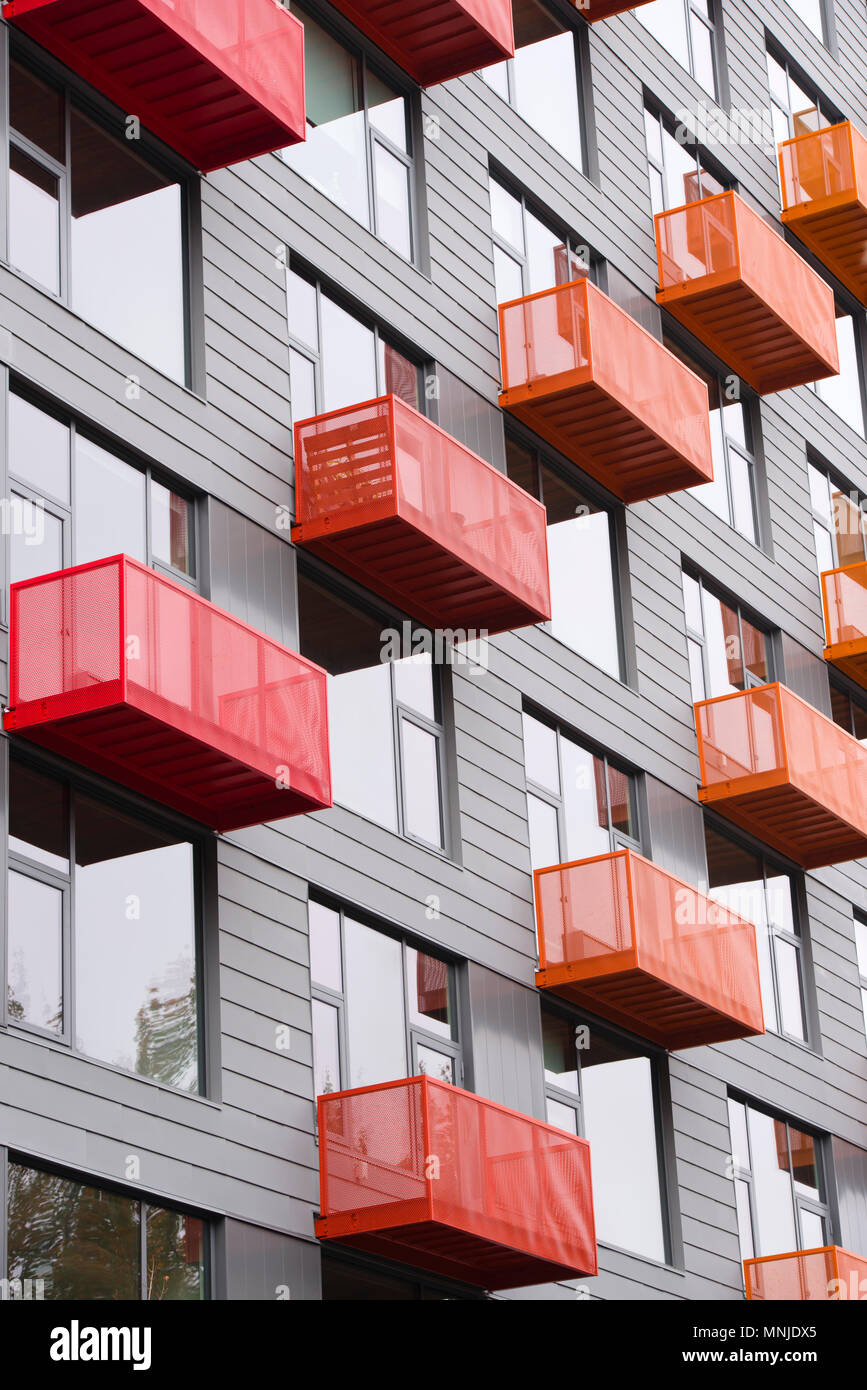 Bright red and orange metal wires protruding balconies in gray modern high-rise building with big windows and avant-garde architecture in Pearl Distri Stock Photo