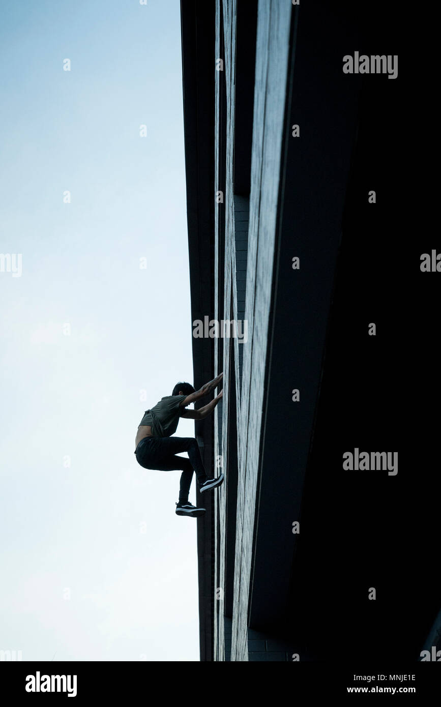 Male park athlete lowers off side of building in downtown Denver, Colorado, USA Stock Photo