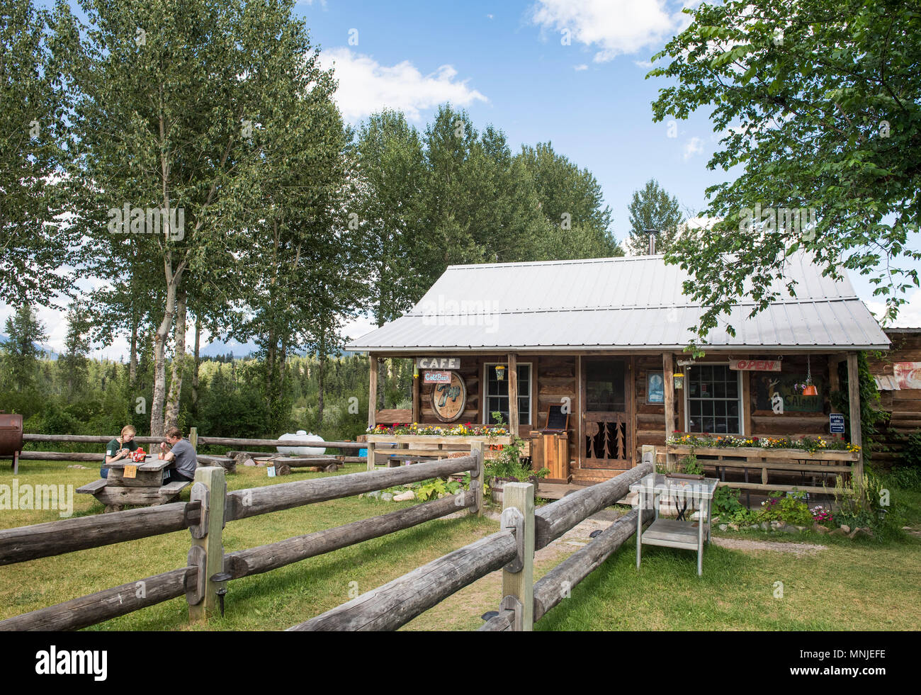 Hikers Enjoying Drink Outside Bar In Log Cabin Polebridge