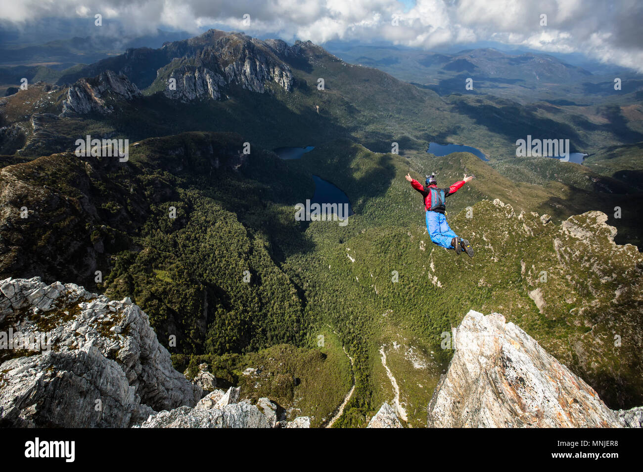 High angle view of BASE jumper in free fall right after jumping off tall cliff, New South Wales, Australia Stock Photo