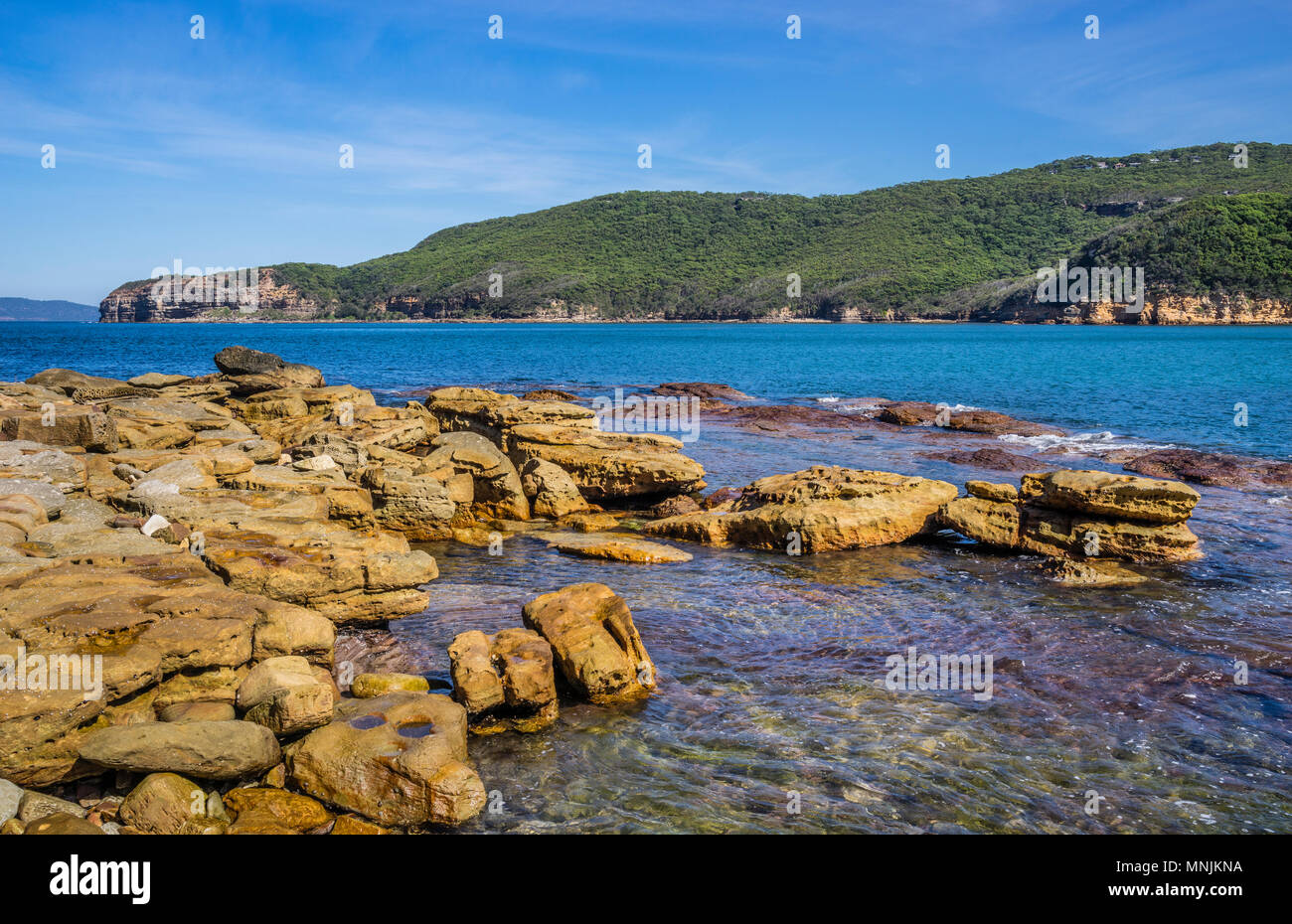 rocky shoreline at the northern escarpment of Maitland Bay with view of Gerrin Point in the distance, Bouddi National Park, Central Coast, New South W Stock Photo