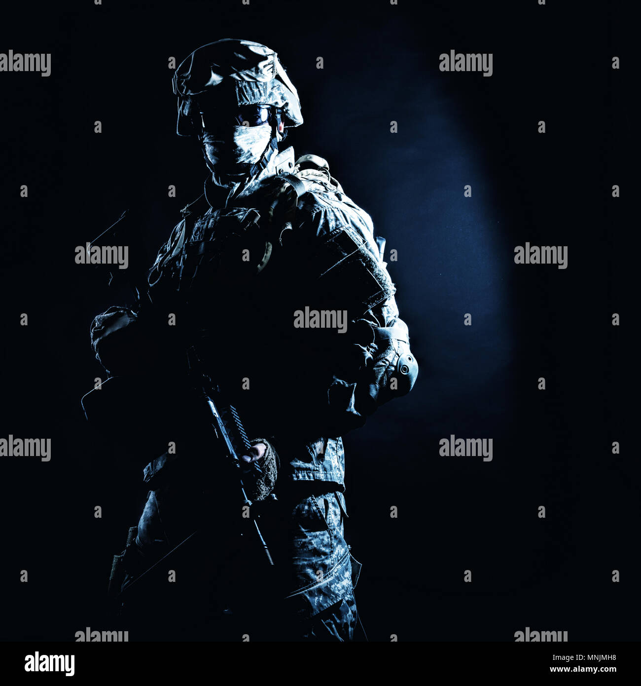 Infantry rifleman standing with weapon in darkness Stock Photo