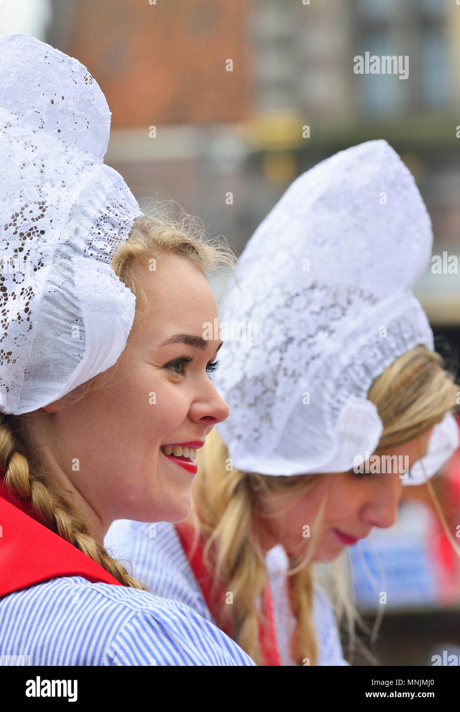 Dutch girls in traditional  costume at the cheese market in Alkmaar Cheese Market, Holland 'cheese girls' sells samples at the Alkmaar Cheese market Stock Photo