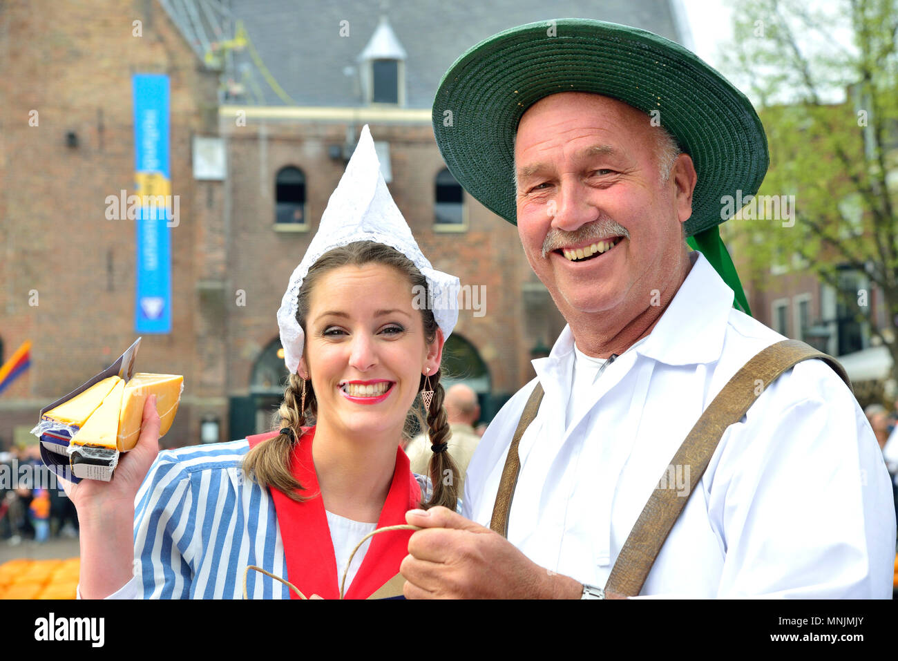 Attractive couple selling cheeses to the onlooking crowd at the Alkmaar cheese market, Holland, The Netherlads Stock Photo