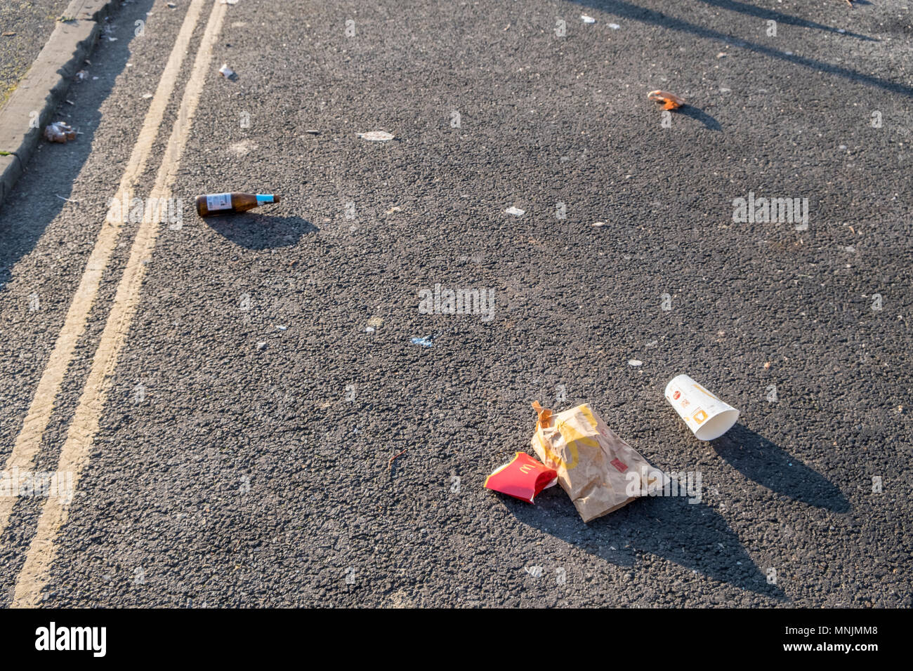 Litter on a road. Fast food waste, drinks containers and other rubbish left on the roadside, Nottingham, England, UK Stock Photo