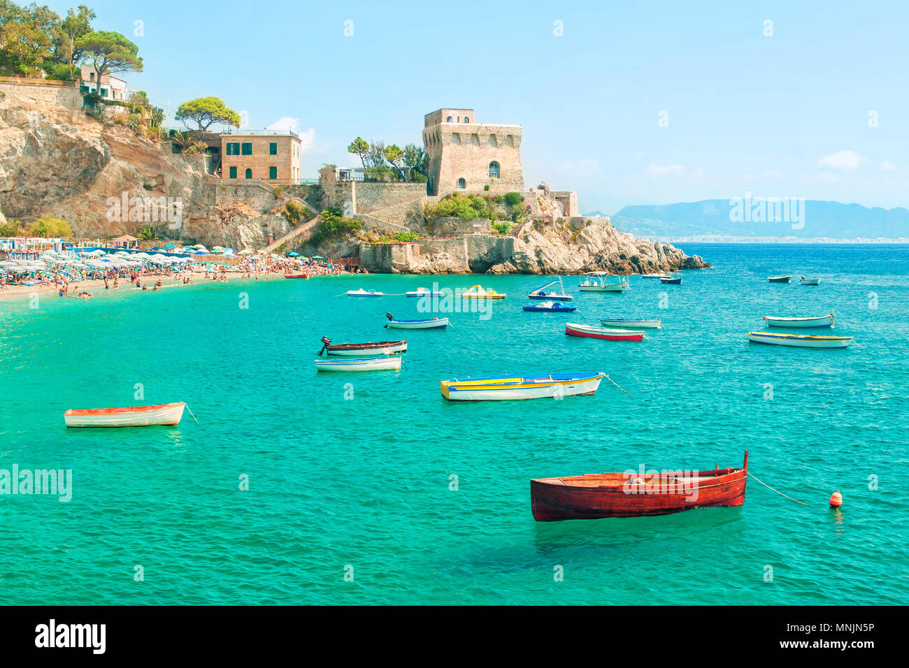 beautiful view of moored fishing boats at Erchie beach with old castle in background on sunny summer day, Amalfi coast, Salerno, Campania, Italy Stock Photo