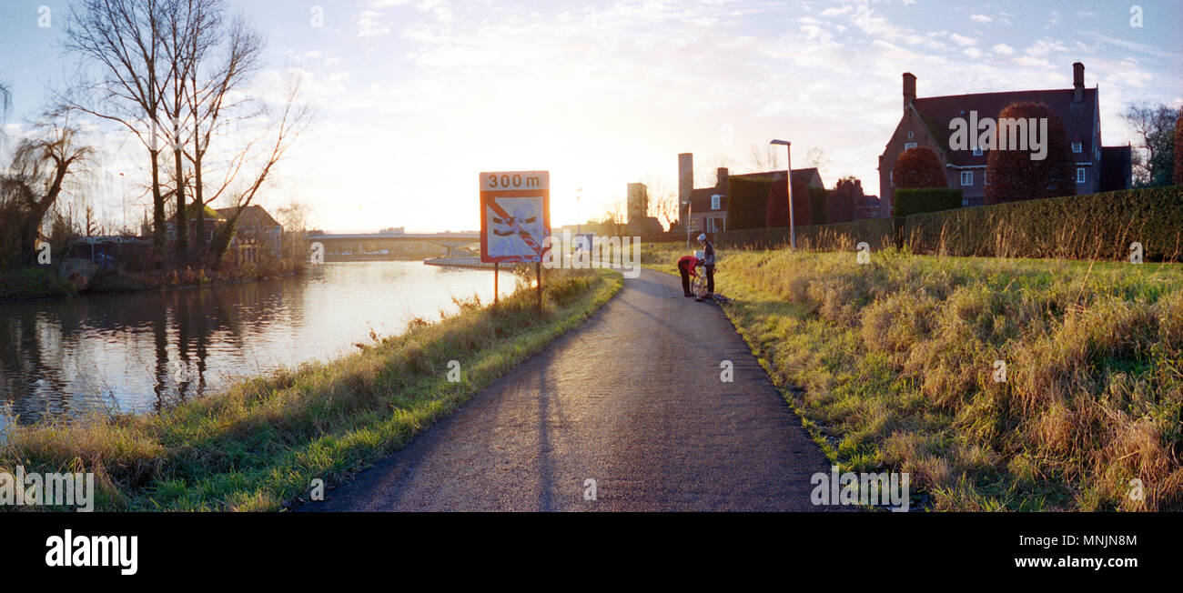cyclist changing a tire in the evening sun at autumn Stock Photo