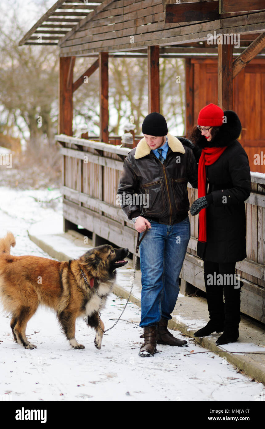 Happy couple with dogs in winter forest. Lovely moments outdoor ...