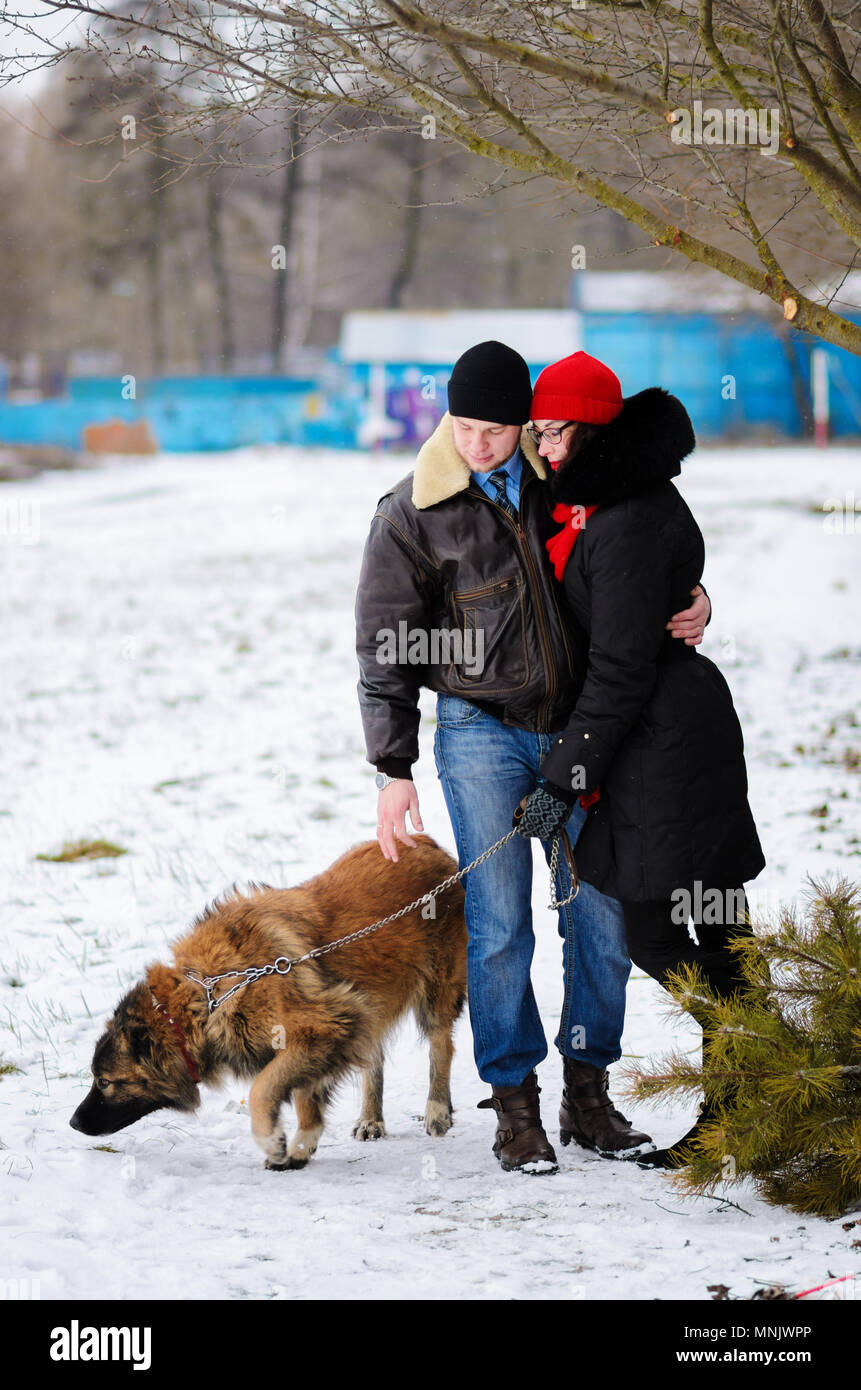 Happy couple with dogs in winter forest. Lovely moments outdoor holidays. Stock Photo