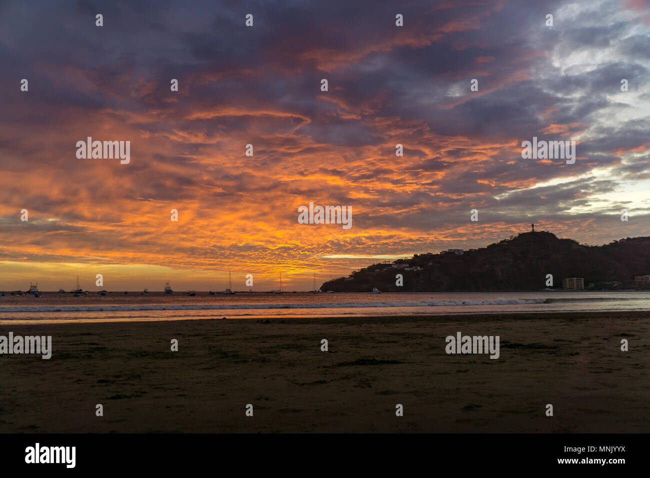 Colorful clouds at sunset at the beach with boats. San juan del sur, nicaragua. Stock Photo