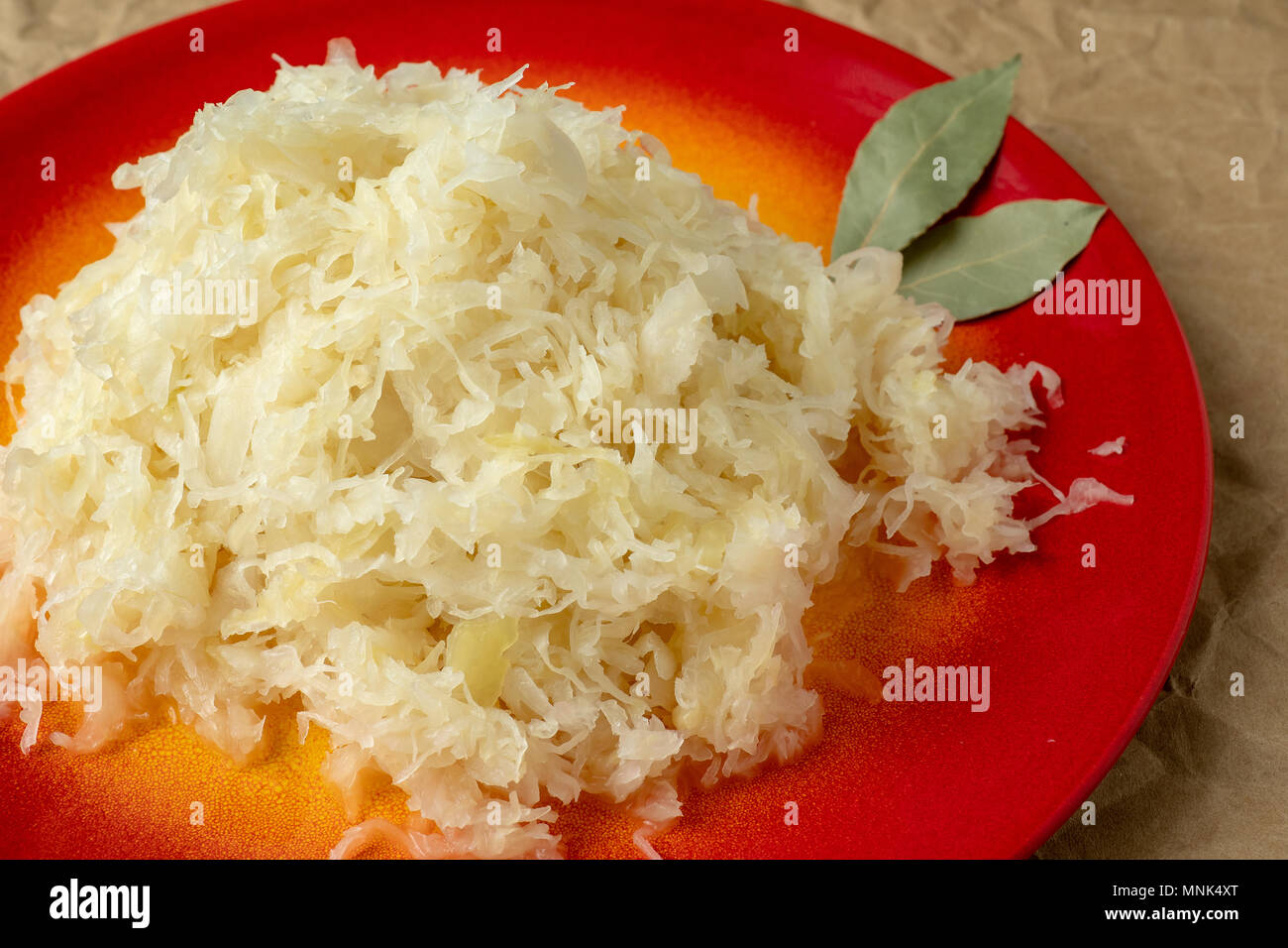 Fermented cabbage. Red plate of sauerkraut (pickled white cabbage Stock