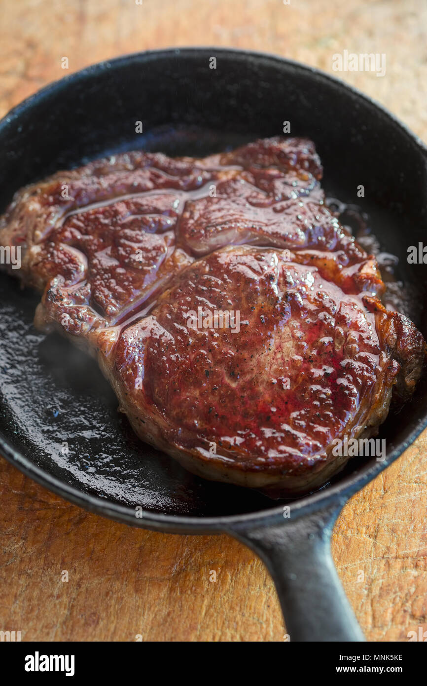 Rib eye steak fried on vegetable oil on iron cast Stock Photo Alamy