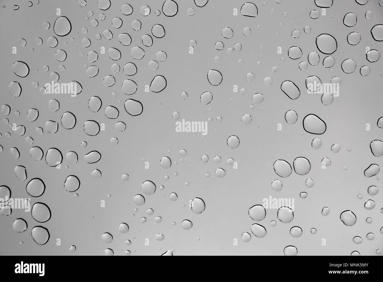 Rain drops on window glasses surface with cloudy background Stock Photo