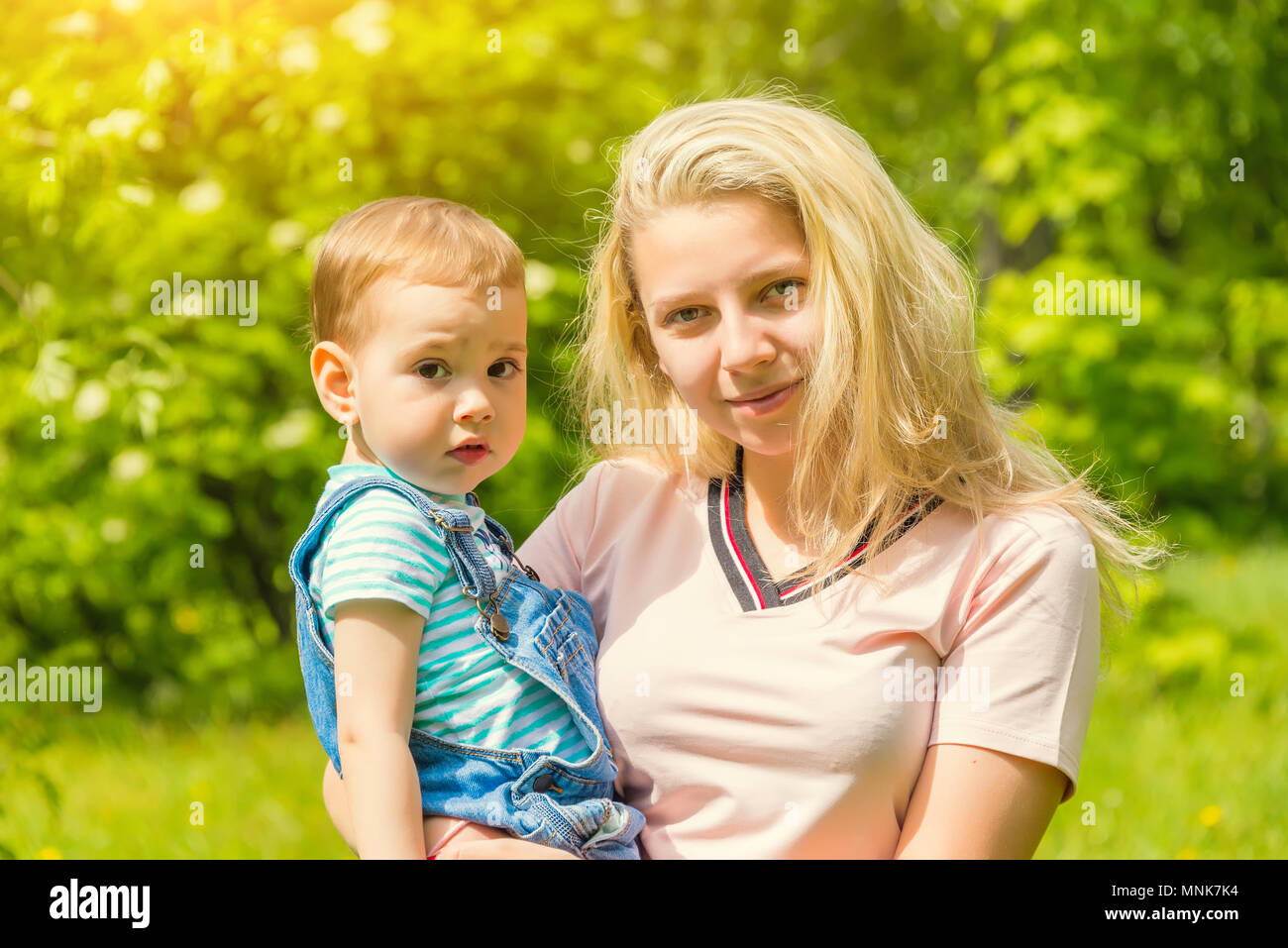 mother and child in nature in the Park, resting on the green grass in ...
