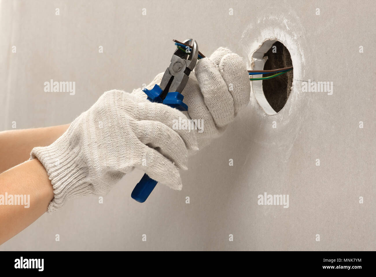 hand of electrician cutting wires with clippers during repair Stock