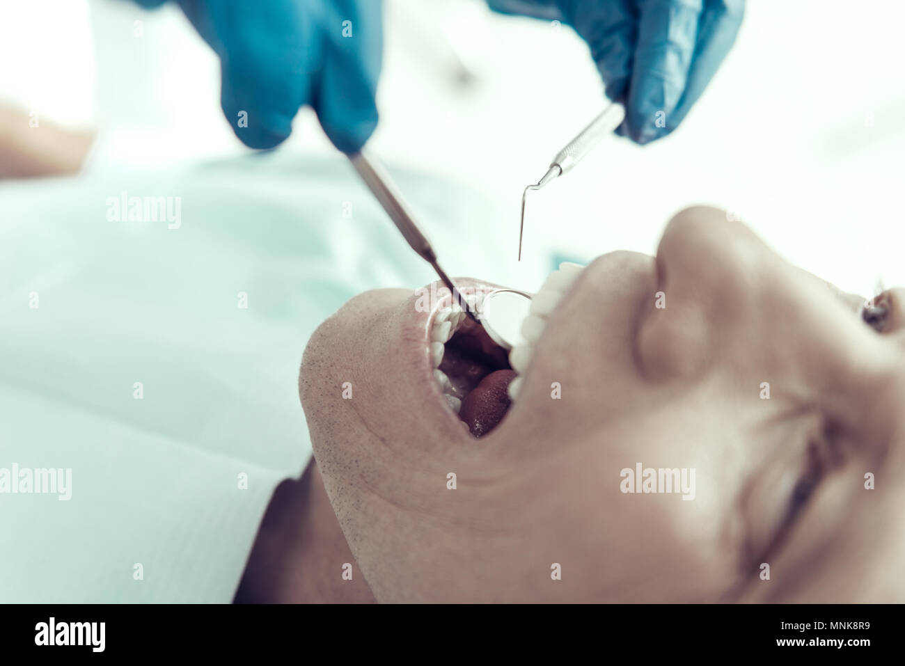 Dental mirror in the mouth of a young patient Stock Photo - Alamy