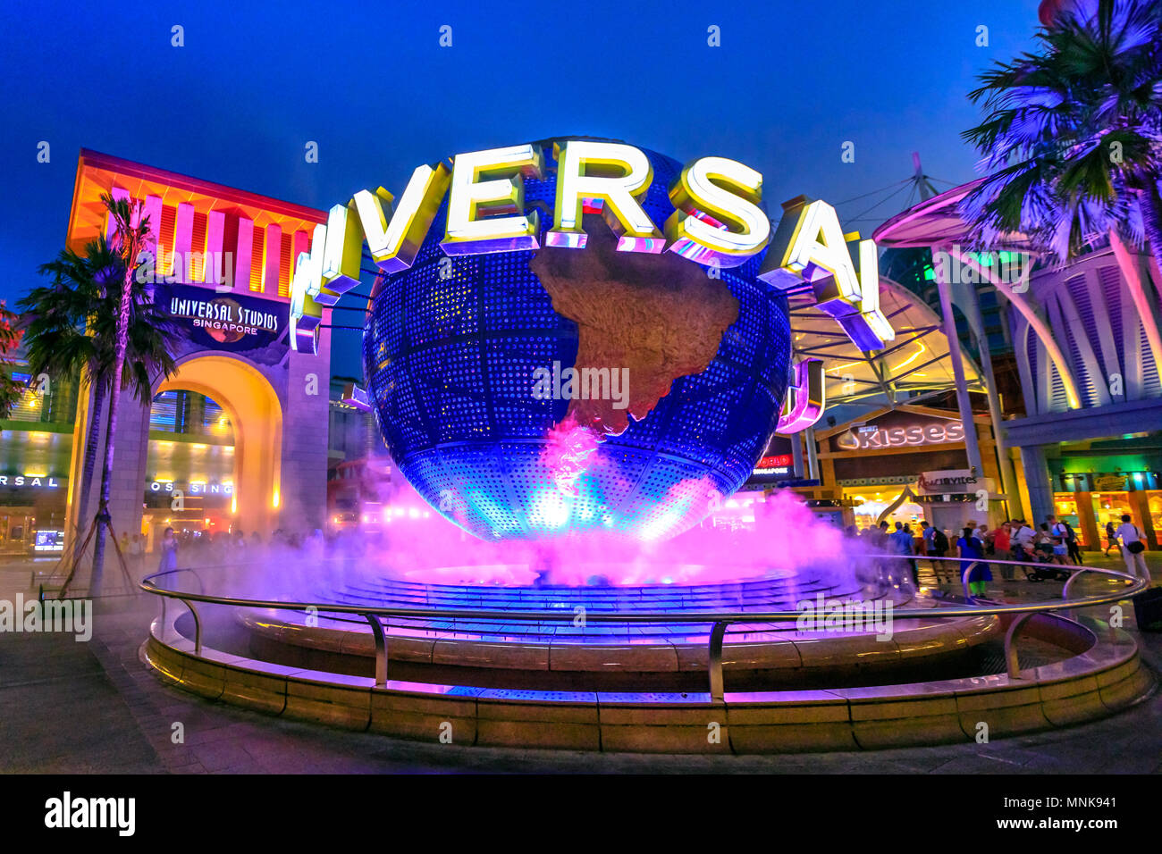 Singapore - May 2, 2018: Universal Studios with luminous globe in Sentosa island at blue hour with pink lights. Universal Studios Singapore is southeast Asia's first Hollywood movie theme park. Stock Photo