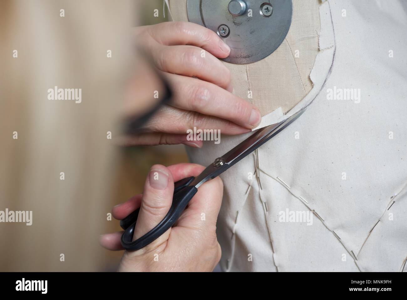 Pattern Maker (Fashion): a real Pattern Maker/Pattern Cutter at work on a  calico toile on a model stand, or mannequin Stock Photo - Alamy