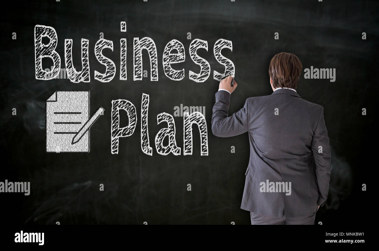 Businessman paints business plan on blackboard concept. Stock Photo
