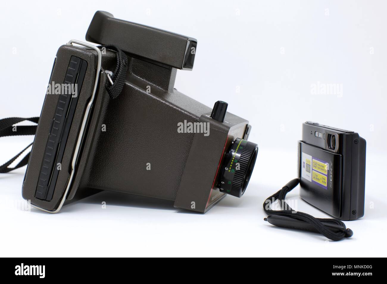 Old fashioned Polaroid instant camera next to a modern