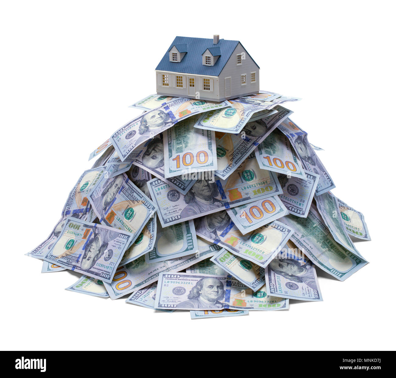 House on Top of a Mound of Cash Isolated on a White Background. Stock Photo