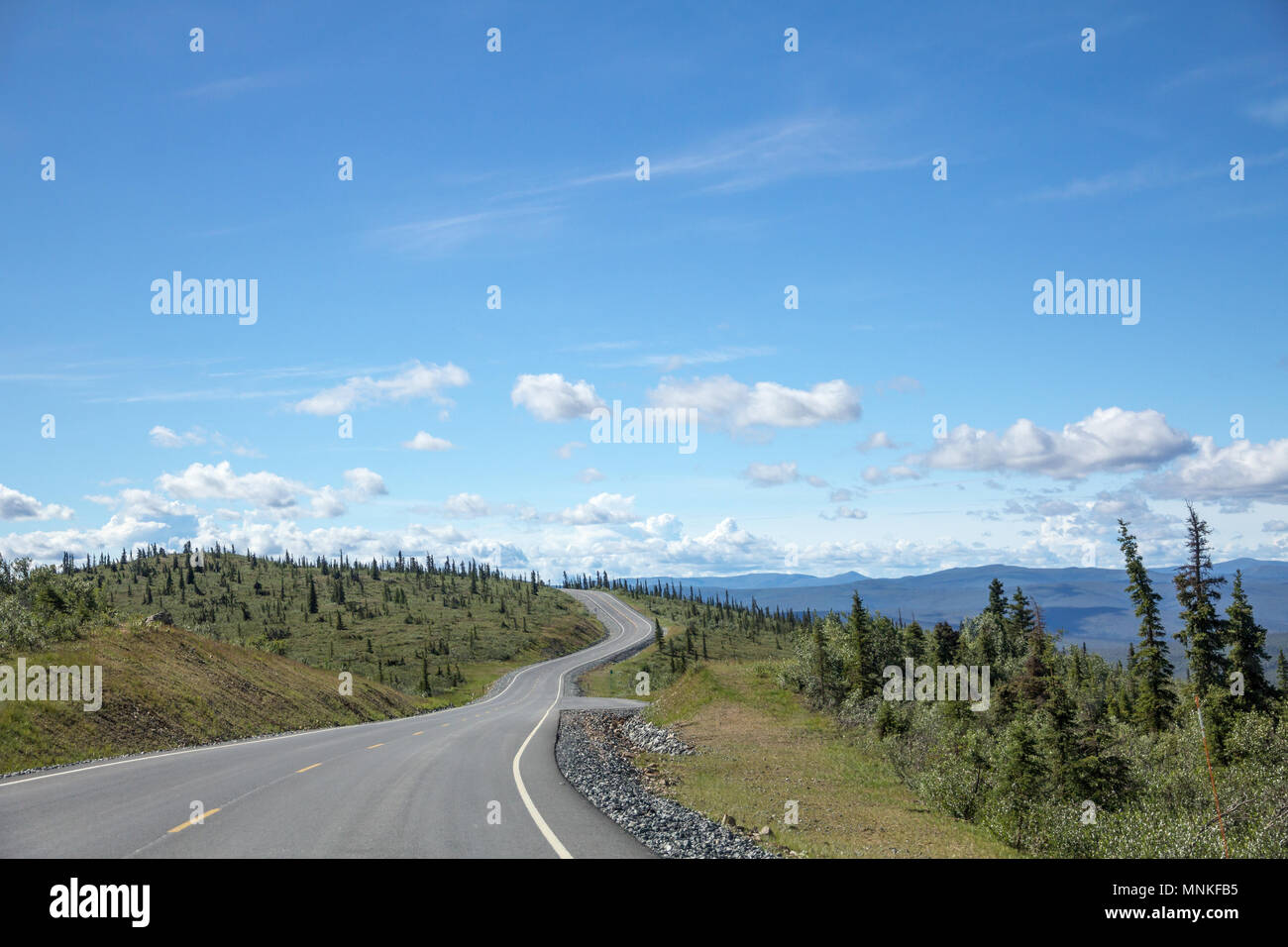 Aptly named 'Top of the World' Highway links Chicken, Alaska with Dawson City, Yukon. Winding along tops of mountain ridges road passes stunted forest Stock Photo