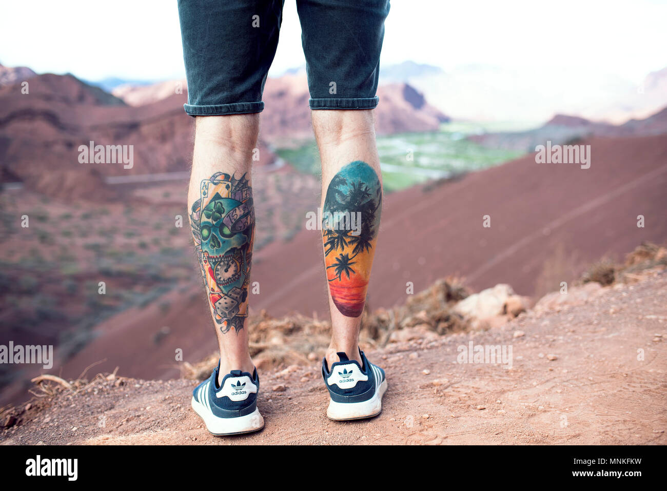Coloured calf tattoos on male. Boy looking at the scenery at Cafayate, Argentina. Stock Photo