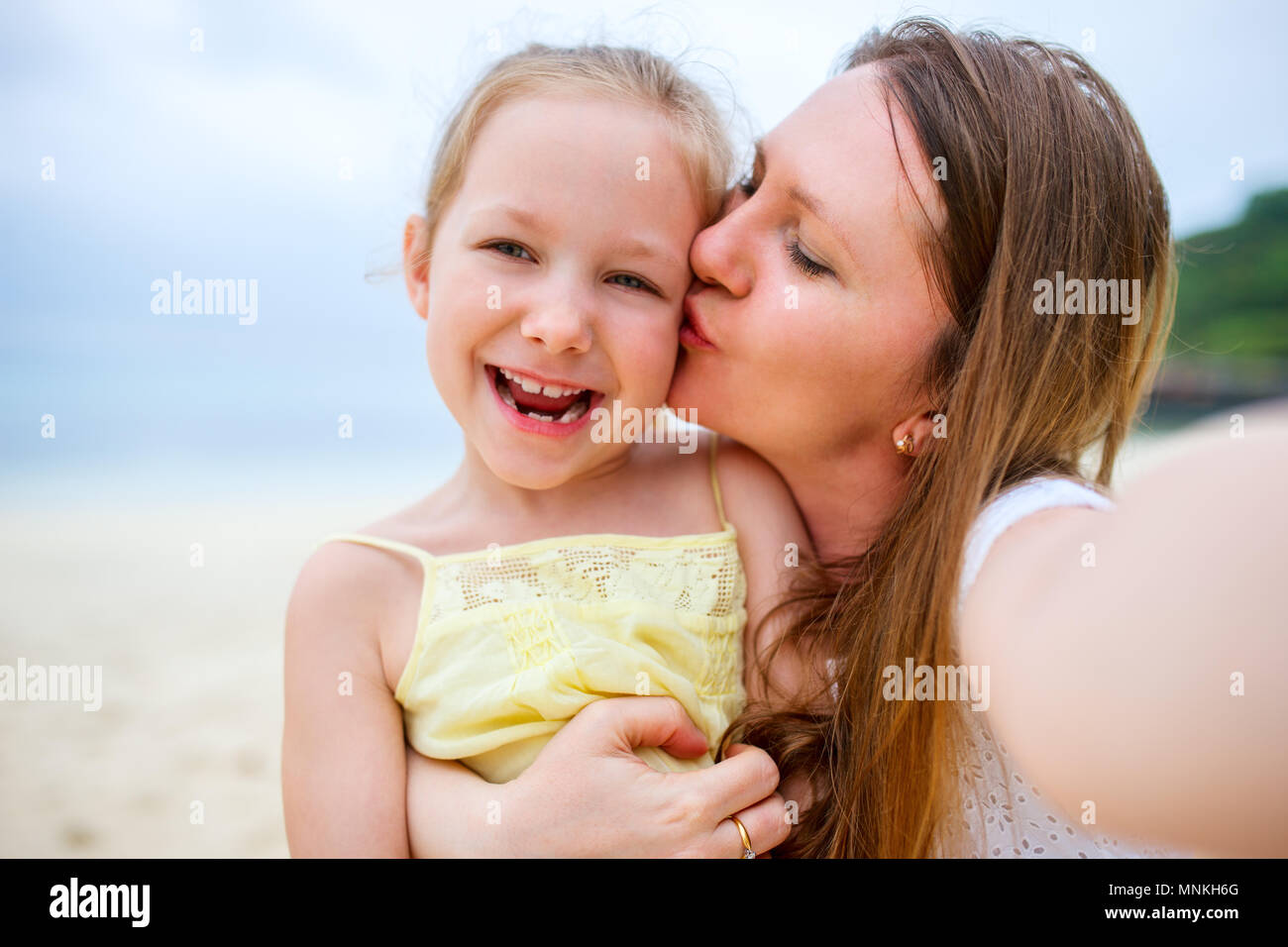 Happy family mother and her adorable little daughter at beach making selfie Stock Photo