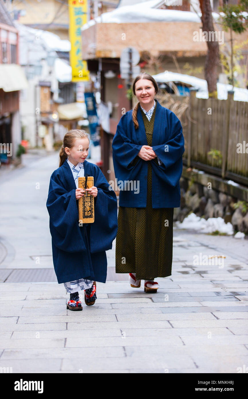 Family of mother and daughter wearing yukata traditional Japanese kimono at street of onsen resort town in Japan. Stock Photo