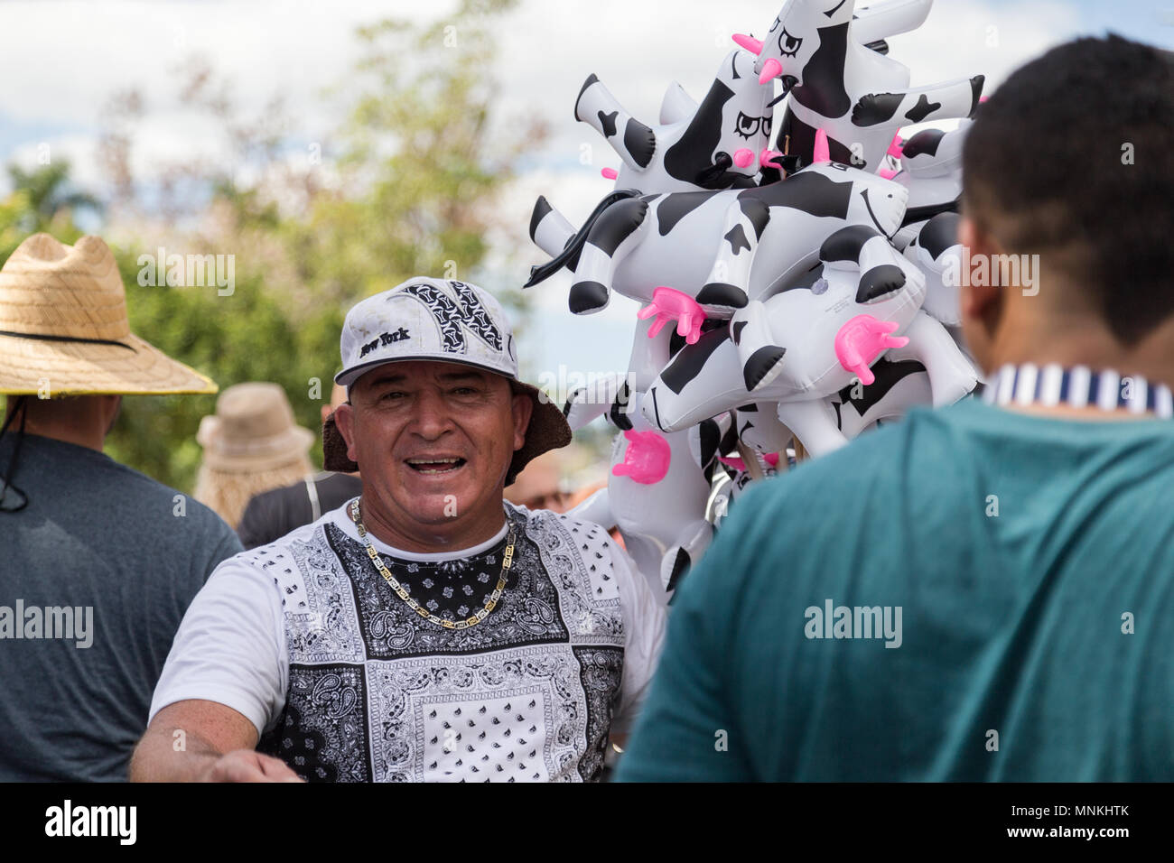 A novelty balloon vender walk through the crowd with a smile on his face at Fiesta de la Novilla, San Sebastian, Puerto Rico. Stock Photo