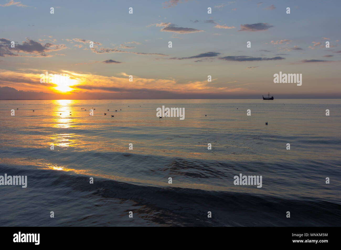 Ship in the sea at sunset Stock Photo - Alamy