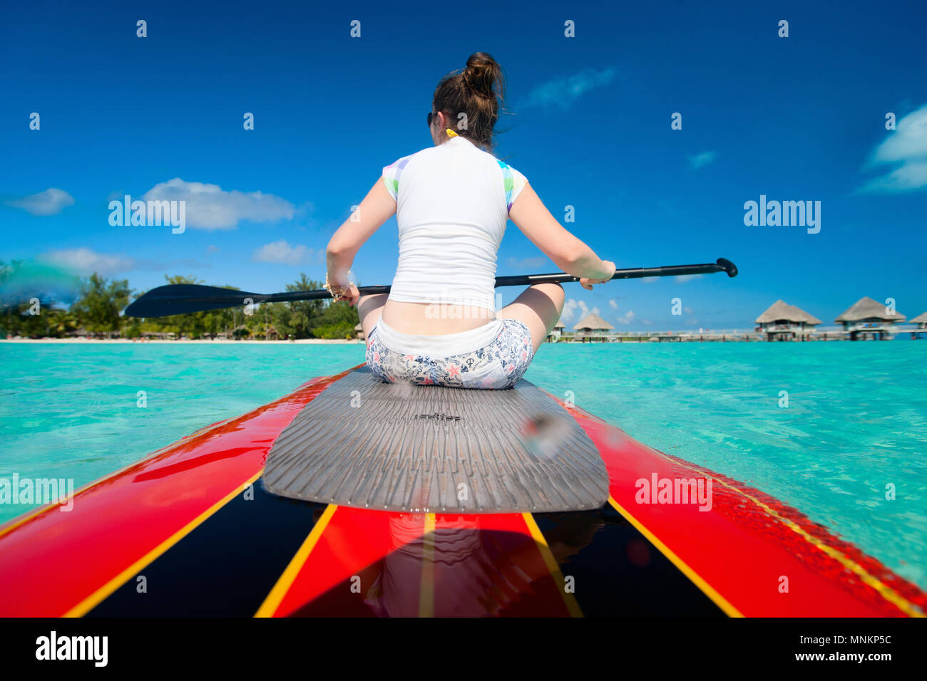 Back view of young sporty woman on paddle board Stock Photo