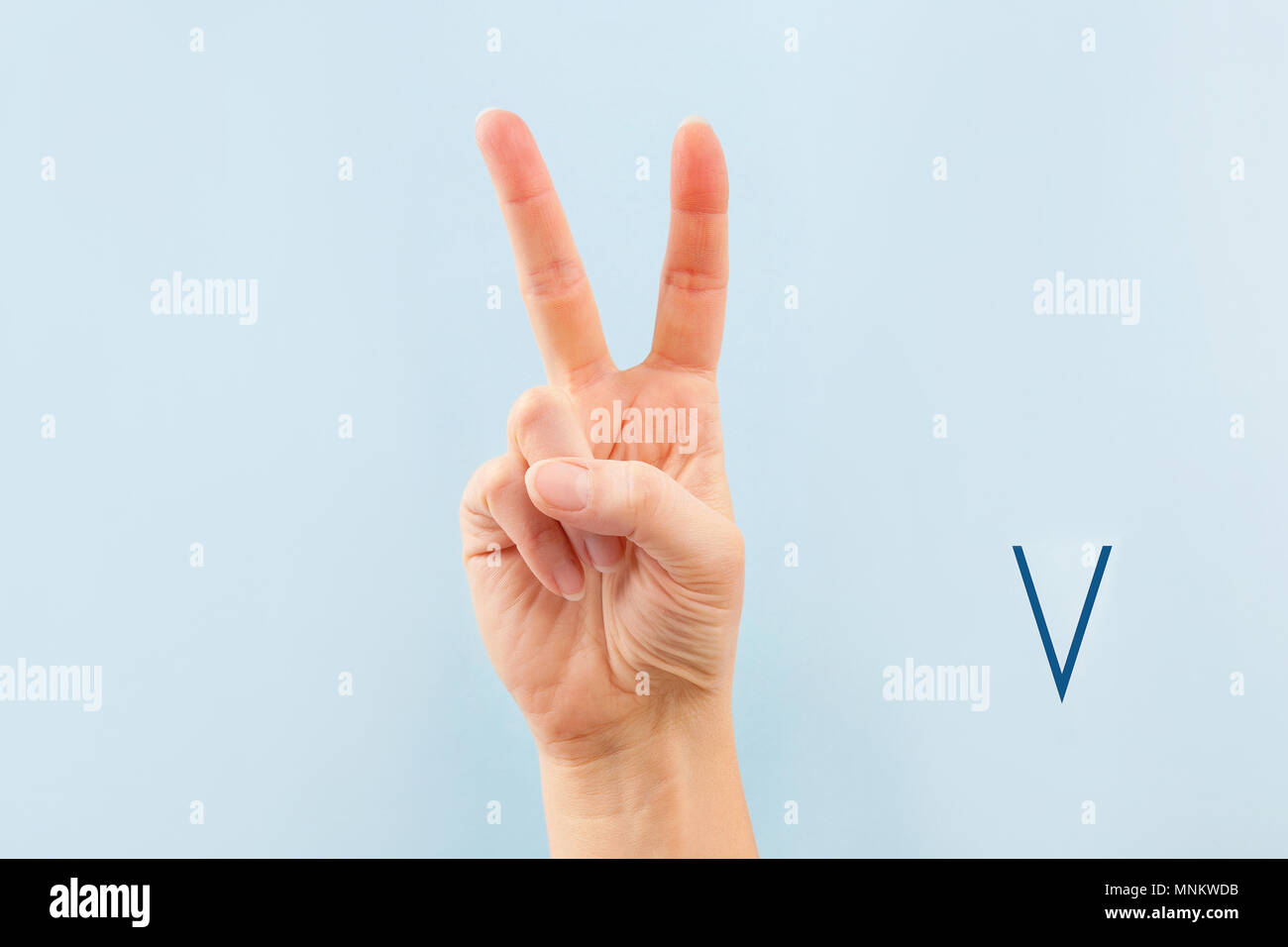 American sign language. Female hand showing letter V isolated on blue ...