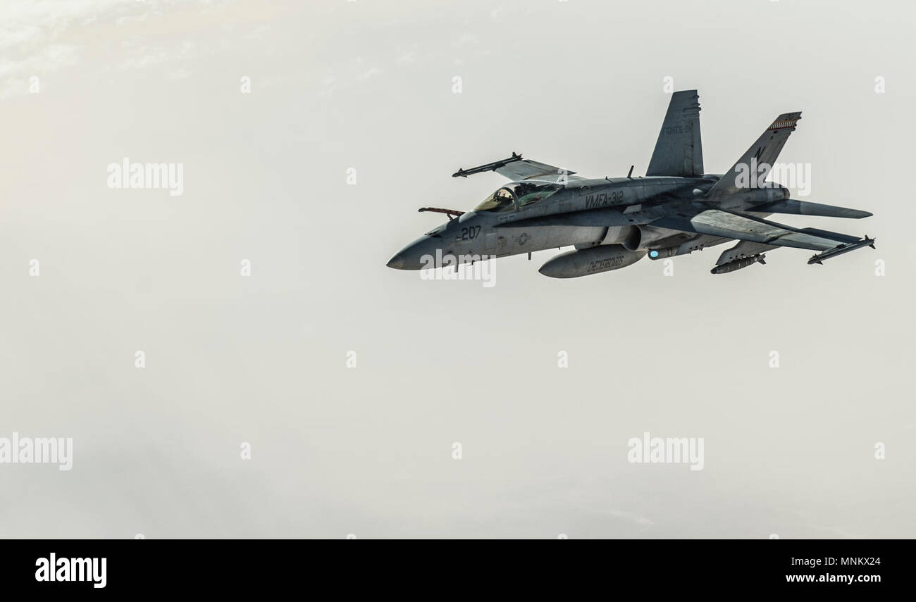 A U.S. Navy F/A-18E Super Hornet departs after receiving fuel from a KC-135 Stratotanker assigned to the 340th Expeditionary Air Refueling Squadron during a refueling mission on above Iraq March 9, 2018. The F/A-18E and F model are twin-engine carrier capable multirole fighter aircraft variants with the E model being a single-seat and the F model designated as a tandem seat. Stock Photo