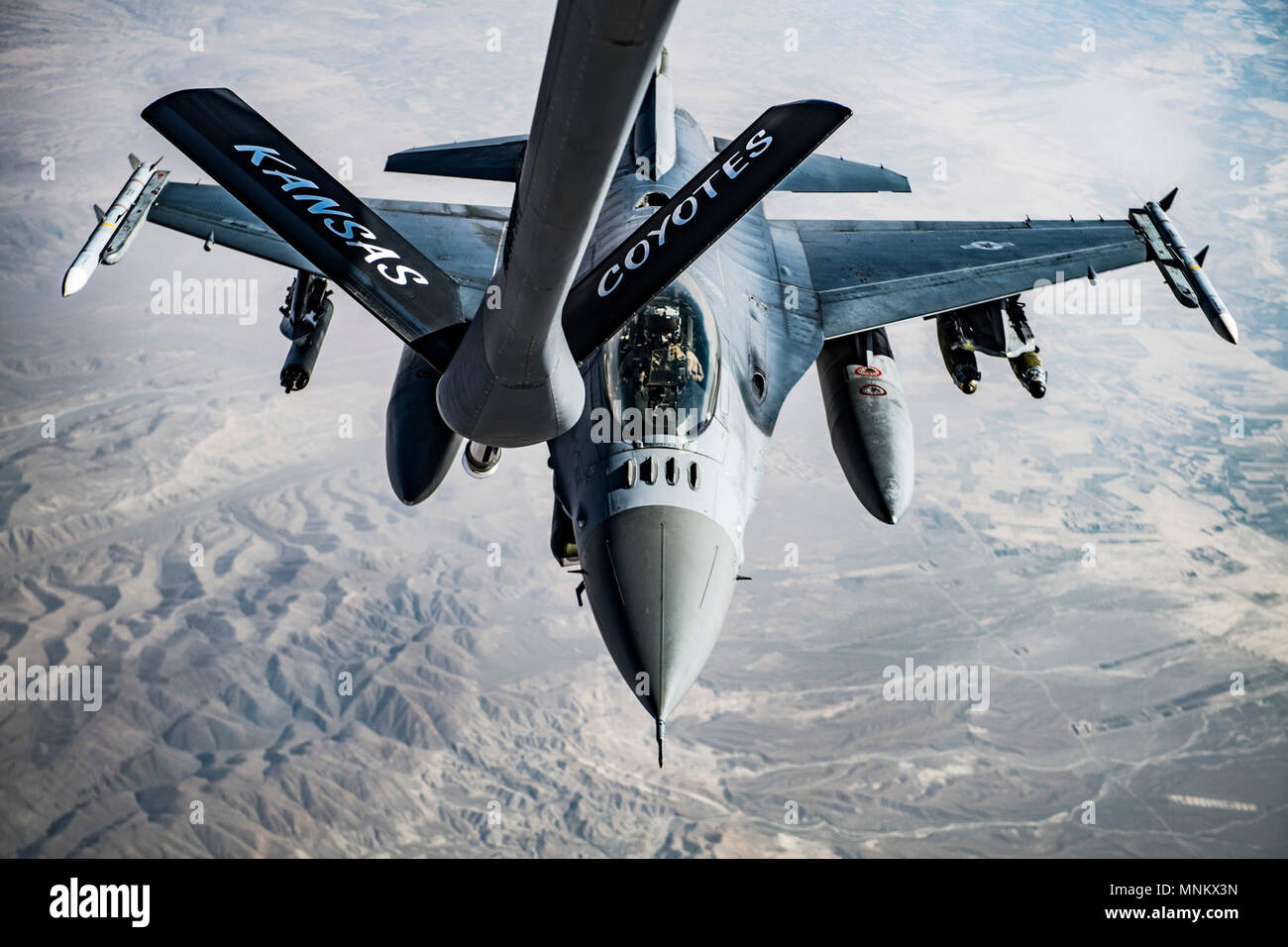 A U.S. Air Force F-16C Fighting Falcon pilot maneuvers in to position to conduct refueling operations with a KC-135 Stratotanker, assigned to the 340th Expeditionary Air Refueling Squadron Detatchment 1, over Afghanistan in support of Operation Freedom's Sentinel, March 11, 2018. The F-16's capabilities include air superiority, fighter escort, reconnaissance, aerial refueling, close air support, air defense suppression and precision strikes. Stock Photo