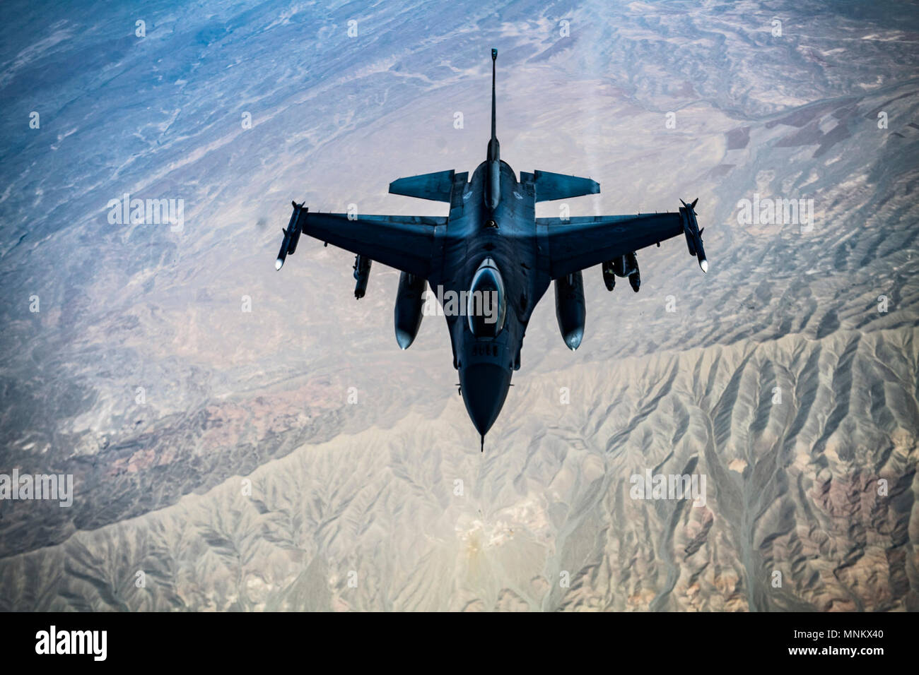 A U.S. Air Force F-16C Fighting Falcon pilot flies in formation while his wingman conducts refueling operations with a KC-135 Stratotanker, assigned to the 340th Expeditionary Air Refueling Squadron Detatchment 1, over Afghanistan in support of Operation Freedom's Sentinel, March 11, 2018. The F-16's capabilities include air superiority, fighter escort, reconnaissance, aerial refueling, close air support, air defense suppression and precision strikes. Stock Photo