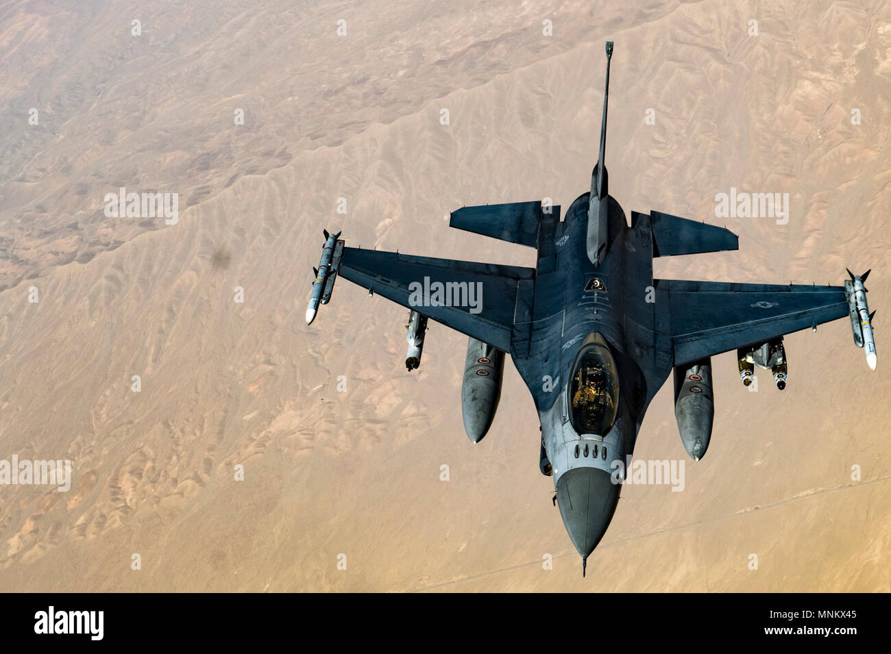 A U.S. Air Force F-16C Fighting Falcon pilot flies in formation while his wingman conducts refueling operations with a KC-135 Stratotanker, assigned to the 340th Expeditionary Air Refueling Squadron Detatchment 1, over Afghanistan in support of Operation Freedom's Sentinel, March 11, 2018. The F-16's capabilities include air superiority, fighter escort, reconnaissance, aerial refueling, close air support, air defense suppression and precision strikes. Stock Photo