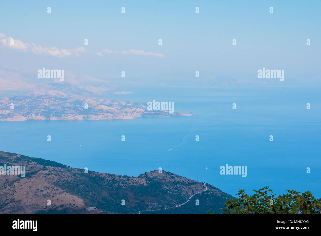 Aerial picture of a cliff, gulf, sea with crystal blue water and boats. landscape from top view from a mountain peak. Travel paradise destination for a couple in searching for adventure. Stock Photo