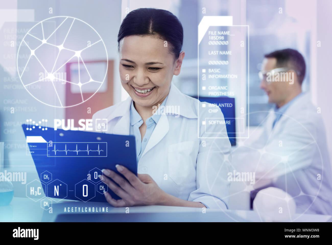 Happy lab worker smiling while looking at her notes Stock Photo - Alamy