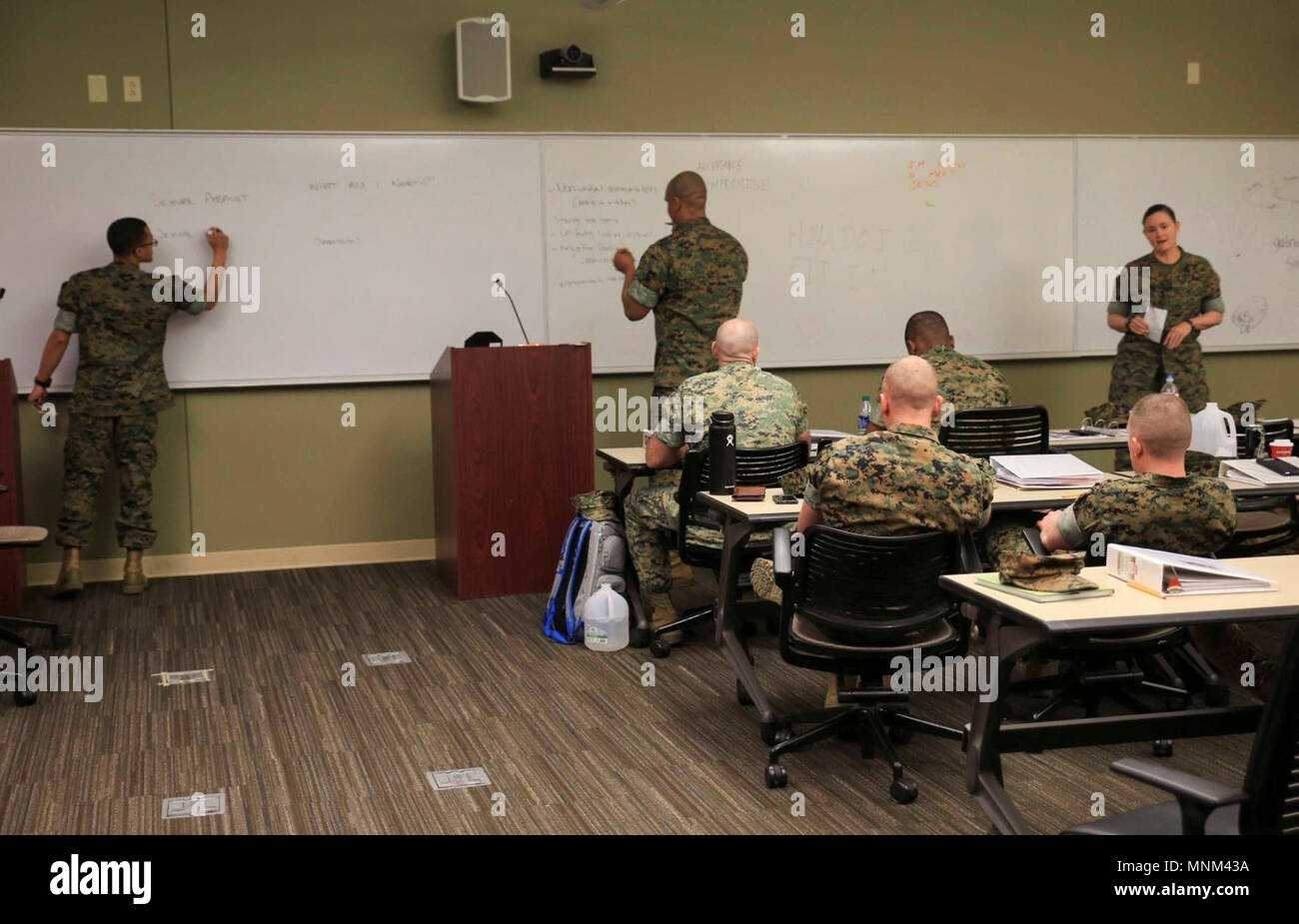 Marines and sailors attending the Operational Stress Control and Readiness train-the-trainer course practice conducting the teach-back portion of their certification, March 14, 2018, at Marine Corps Support Facility New Orleans. In order to become an OSCAR Trainer, the service members have to prove their ability to be able to teach the course and build an OSCAR team. Stock Photo