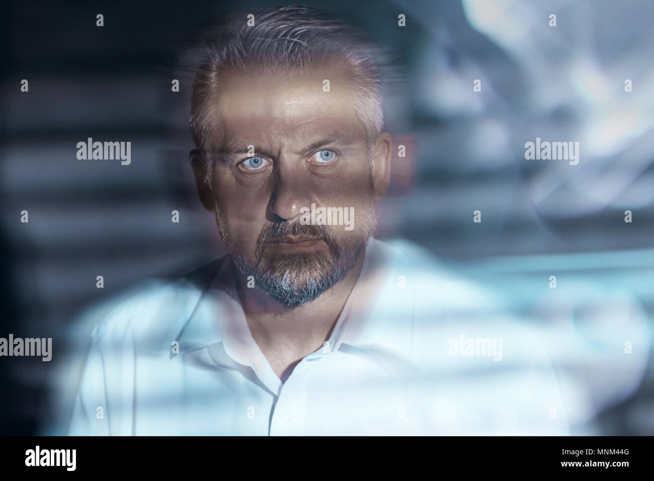 Blurred closeup of a troubled middleaged man's face with eyes wide open. Depression and mental