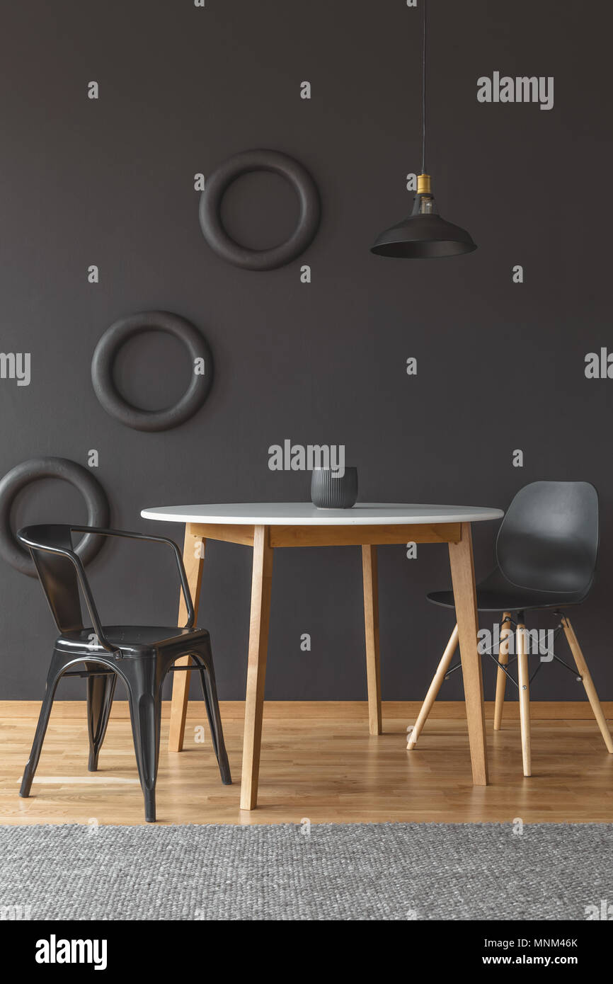 White dining table with black chairs set in an artistic room interior
