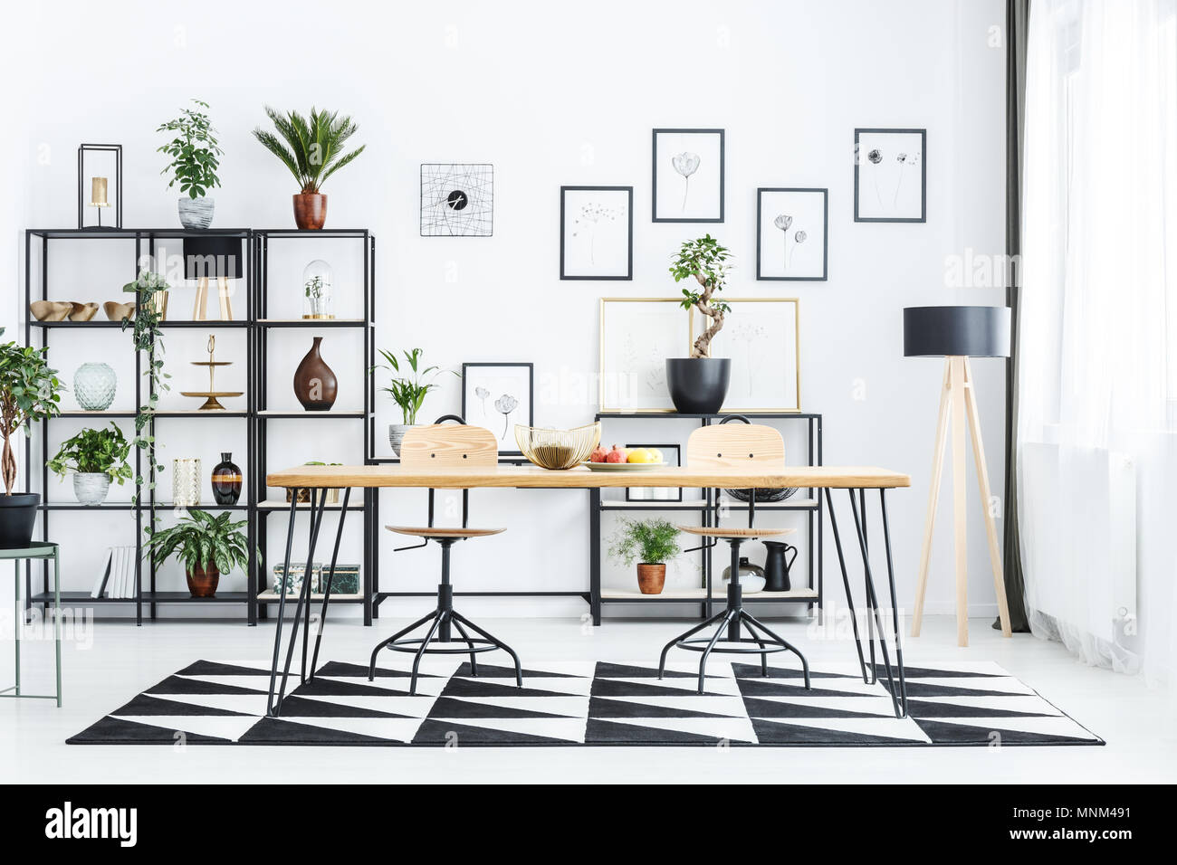 Wooden chair at table on geometric carpet in scandi dining room