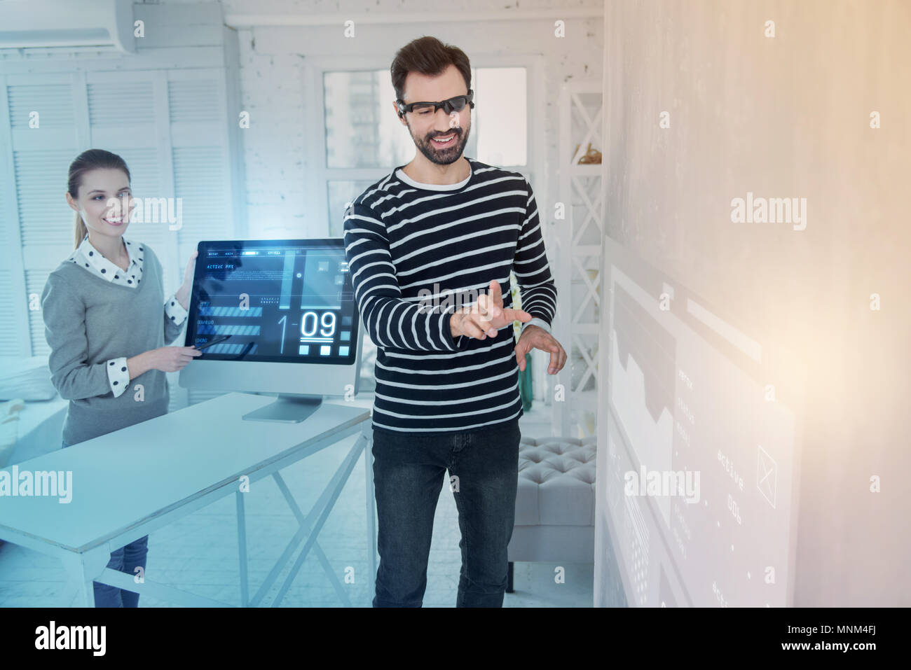 Cheerful web developer wearing virtual reality glasses and smiling Stock Photo