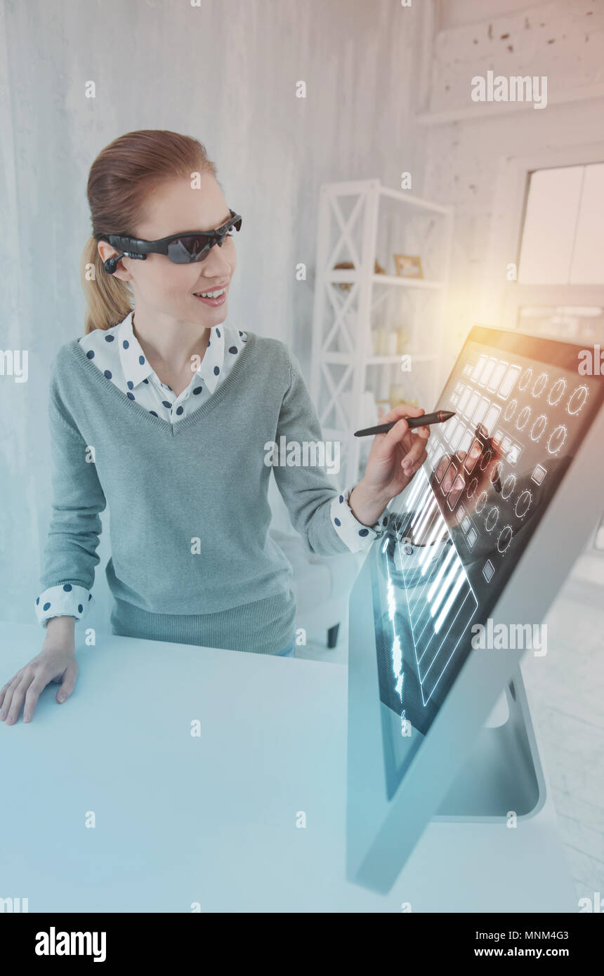 Positive programmer smiling and working with a stylus Stock Photo