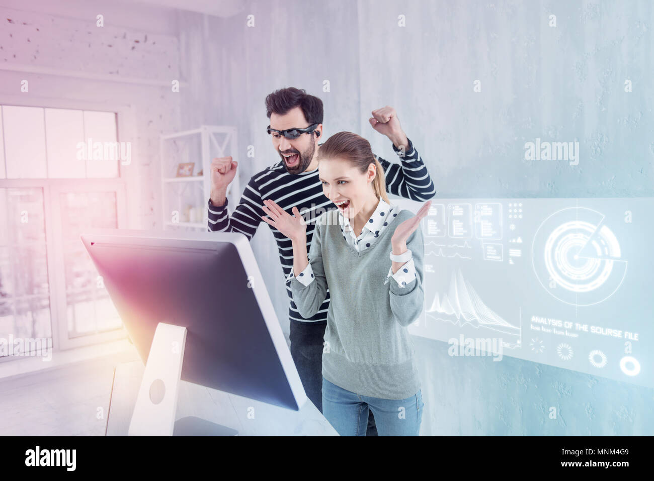 Happy colleagues putting their hands up and shouting Stock Photo