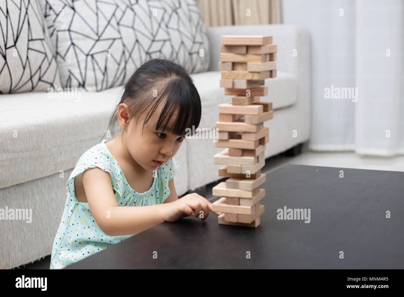 Asian Chinese little girl playing wooden stacks at home Stock Photo - Alamy