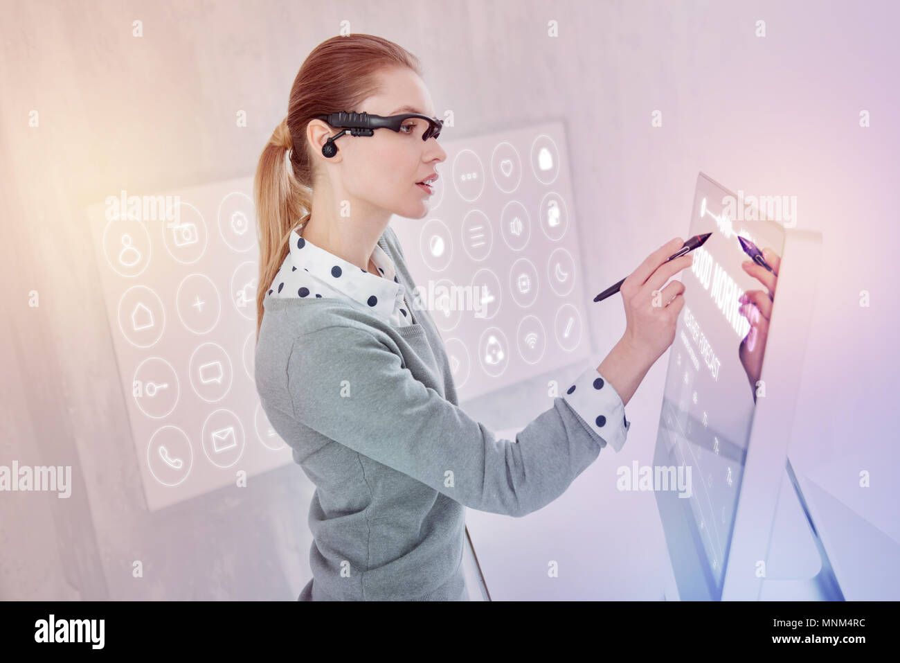 Attentive programmer using a stylus while working on her computer Stock Photo
