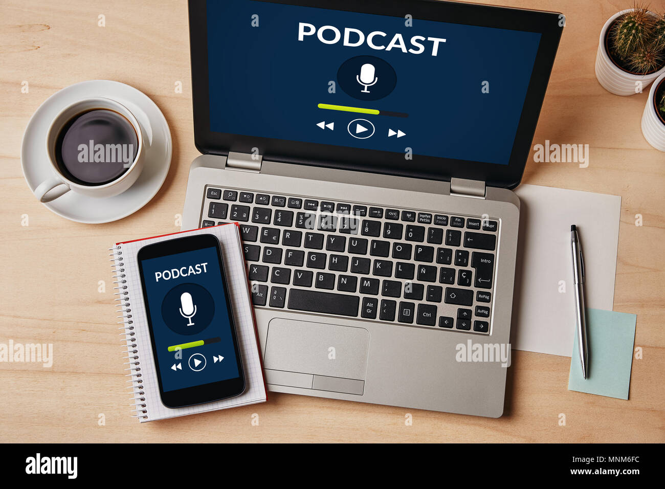 Podcast concept on laptop and smartphone screen over wooden table. All screen content is designed by me. Flat lay Stock Photo